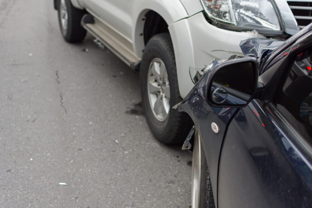 Ein weißer SUV und ein schwarzes Auto sind frontal kollidiert, beide mit Frontschaden - ein Fall für Kfz Gutachten oder Schadensgutachten